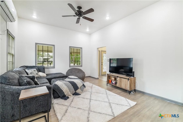living room featuring recessed lighting, a wall mounted AC, a ceiling fan, and light wood-style floors