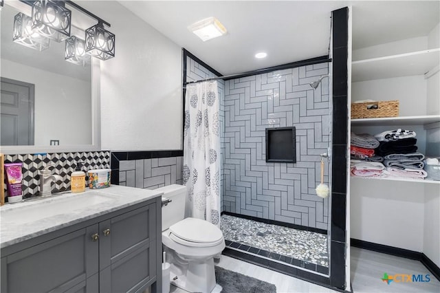 bathroom with recessed lighting, toilet, a tile shower, vanity, and wood finished floors
