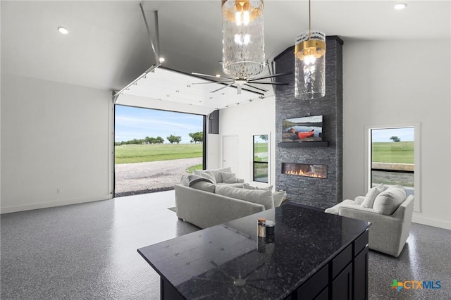 295 Honey Bee Ln, Rogers, TX 76569 - kitchen with a fireplace, baseboards, open floor plan, an inviting chandelier, and dark stone counters