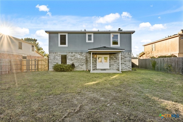 back of house featuring a lawn and a patio area