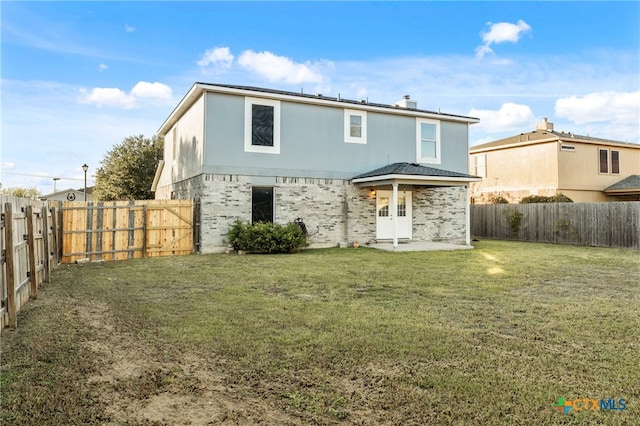 back of property with a patio area and a yard