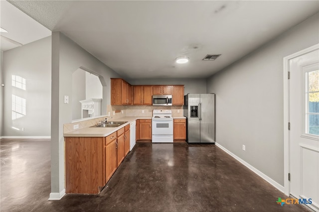 kitchen with appliances with stainless steel finishes, backsplash, and sink