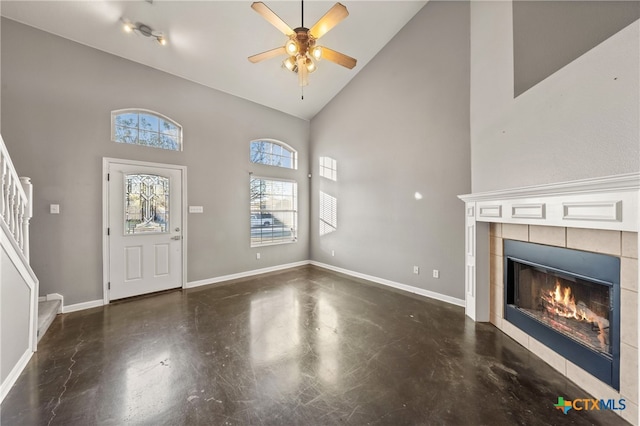 entrance foyer featuring a tile fireplace, ceiling fan, high vaulted ceiling, and track lighting