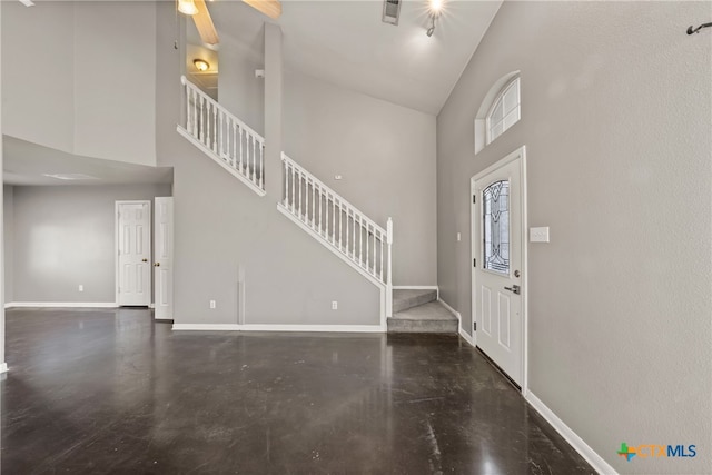 foyer with ceiling fan and high vaulted ceiling