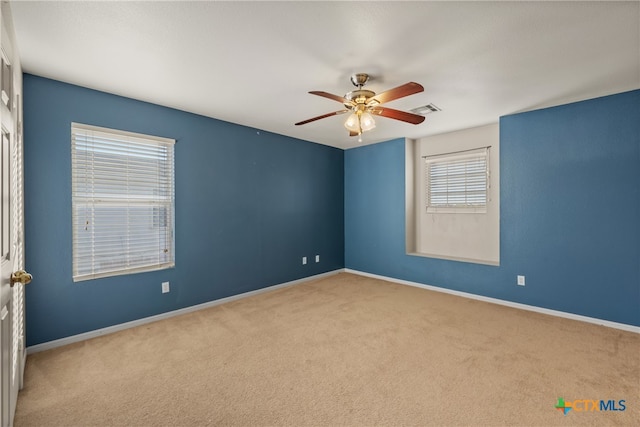 spare room featuring ceiling fan and light colored carpet