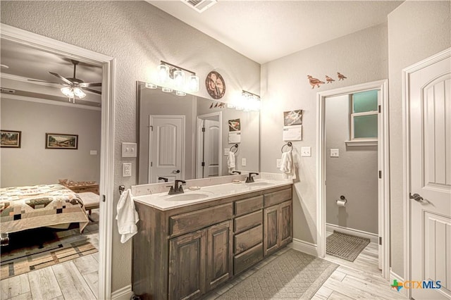 bathroom with vanity, hardwood / wood-style flooring, crown molding, and ceiling fan