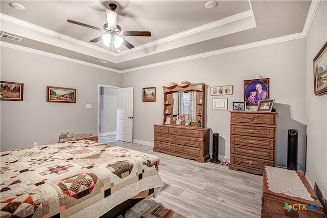 bedroom with ornamental molding, ceiling fan, light hardwood / wood-style floors, and a tray ceiling