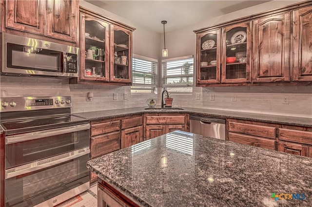 kitchen featuring appliances with stainless steel finishes, tasteful backsplash, sink, hanging light fixtures, and dark brown cabinets