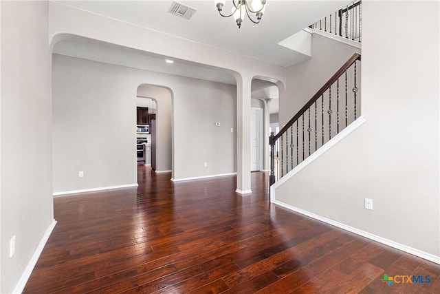 210 Mancos Dr, Georgetown, TX 78626 - unfurnished living room featuring arched walkways, wood-type flooring, and stairway