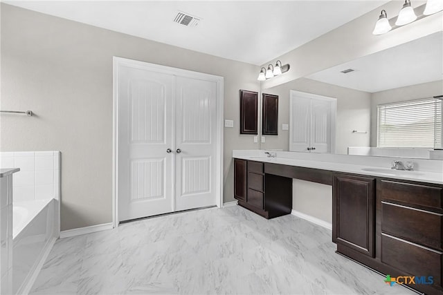 210 Mancos Dr, Georgetown, TX 78626 - bathroom with double vanity, a garden tub, and marble look tiles