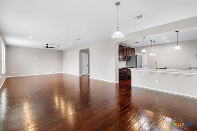 210 Mancos Dr, Georgetown, TX 78626 - unfurnished living room featuring arched walkways, a ceiling fan, dark wood-style floors, and recessed lighting