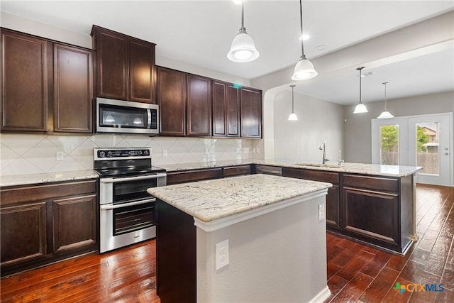 210 Mancos Dr, Georgetown, TX 78626 - kitchen featuring stainless steel appliances, a peninsula, dark wood-style floors, and tasteful backsplash