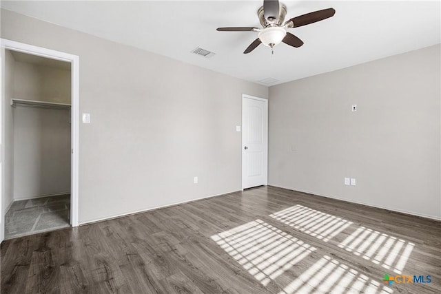 210 Mancos Dr, Georgetown, TX 78626 - unfurnished bedroom featuring wood finished floors, a closet, a walk in closet, and ceiling fan