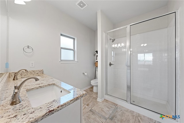 bathroom with toilet, vanity, and walk in shower