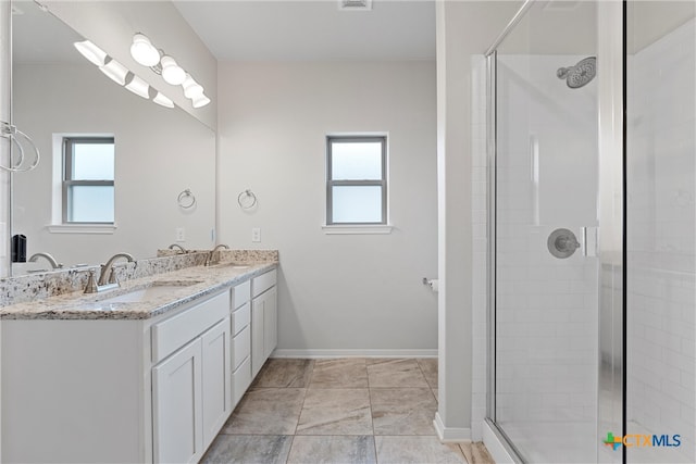 bathroom featuring plenty of natural light, vanity, and a shower with door