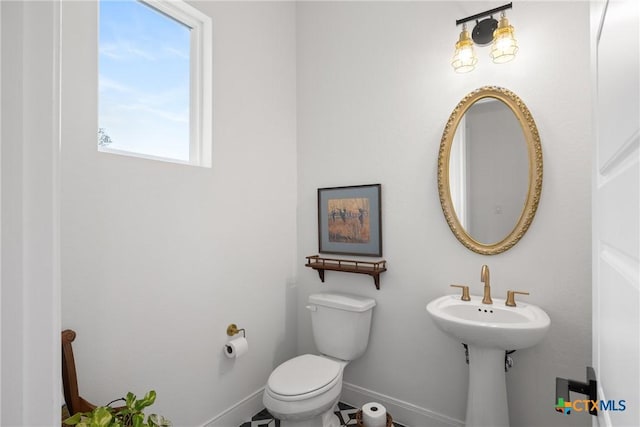 half bath with toilet and baseboards