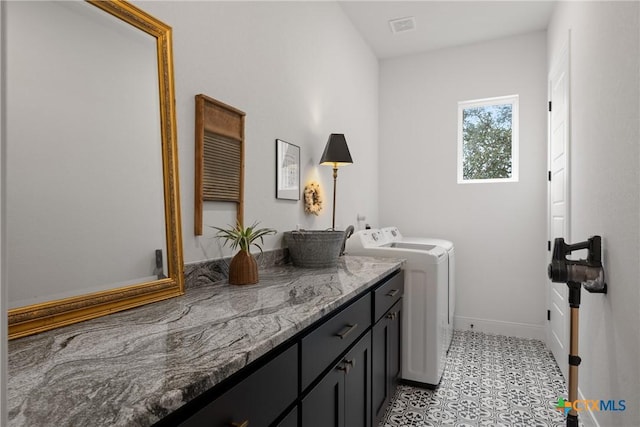 clothes washing area featuring visible vents, cabinet space, baseboards, and separate washer and dryer