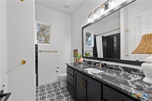 bathroom featuring vanity, a shower with shower curtain, baseboards, visible vents, and toilet