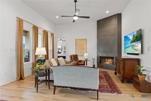 living area featuring a fireplace, recessed lighting, light wood-style floors, and baseboards