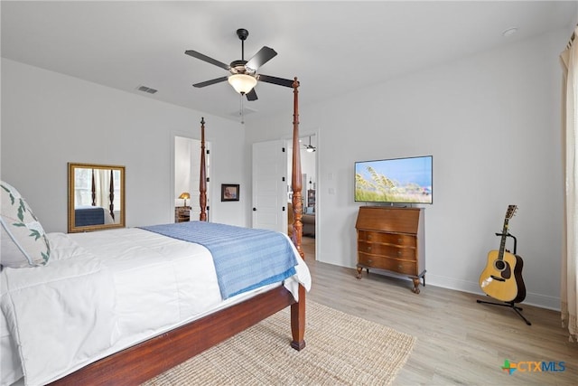 bedroom with a ceiling fan, visible vents, light wood finished floors, and baseboards