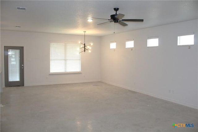 spare room featuring ceiling fan with notable chandelier