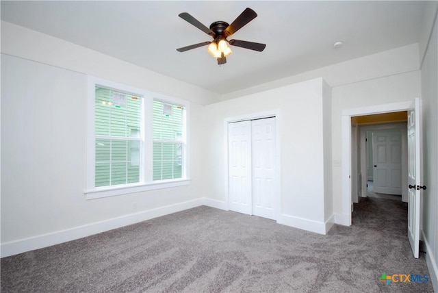 215 E Gonzales St, Yoakum, TX 77995 - unfurnished bedroom featuring a closet, baseboards, a ceiling fan, and carpet floors