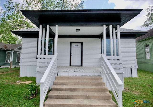 215 E Gonzales St, Yoakum, TX 77995 - doorway to property featuring covered porch and a yard