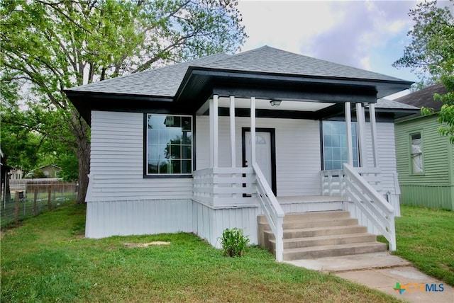 215 E Gonzales St, Yoakum, TX 77995 - bungalow-style home featuring fence, roof with shingles, and a front yard