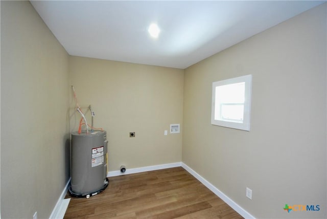 215 E Gonzales St, Yoakum, TX 77995 - laundry area featuring hookup for an electric dryer, hookup for a washing machine, water heater, wood finished floors, and laundry area