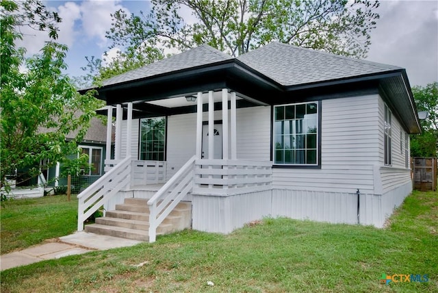 215 E Gonzales St, Yoakum, TX 77995 - bungalow-style home featuring roof with shingles and a front lawn