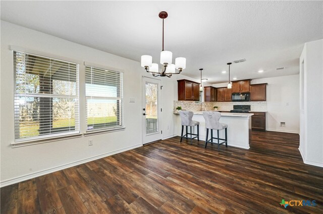 kitchen featuring dark hardwood / wood-style floors, kitchen peninsula, a chandelier, decorative light fixtures, and black appliances