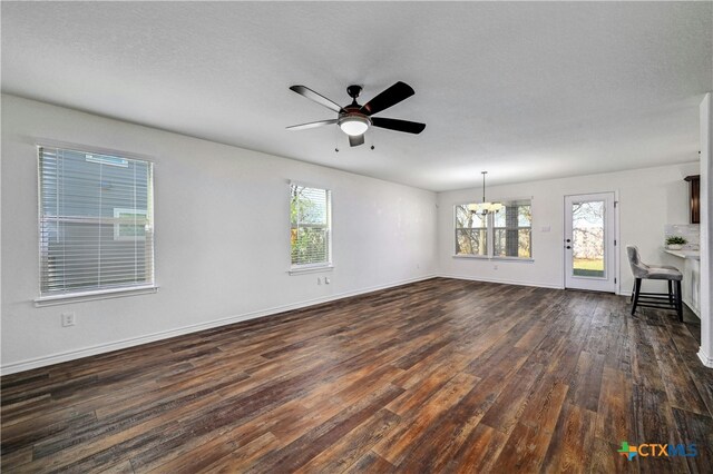 unfurnished living room featuring a textured ceiling, dark hardwood / wood-style flooring, and ceiling fan with notable chandelier