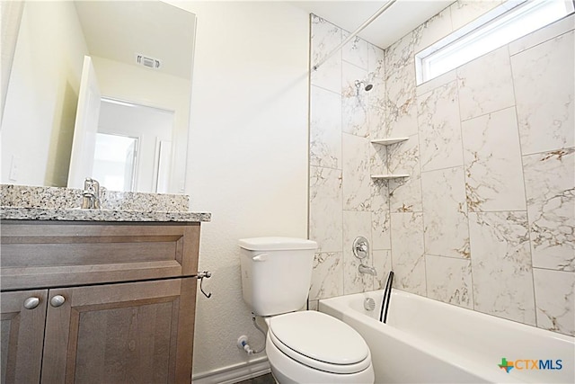 full bathroom featuring vanity, tiled shower / bath, and toilet