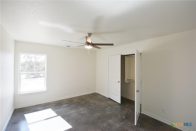 unfurnished bedroom featuring ceiling fan and a textured ceiling