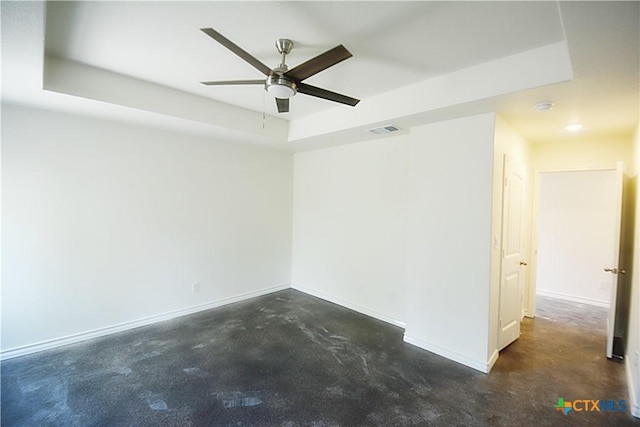 spare room with a raised ceiling and ceiling fan