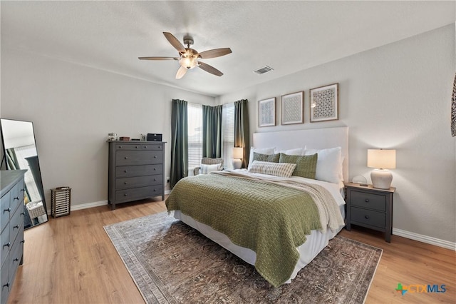 bedroom featuring light wood-type flooring, baseboards, and visible vents