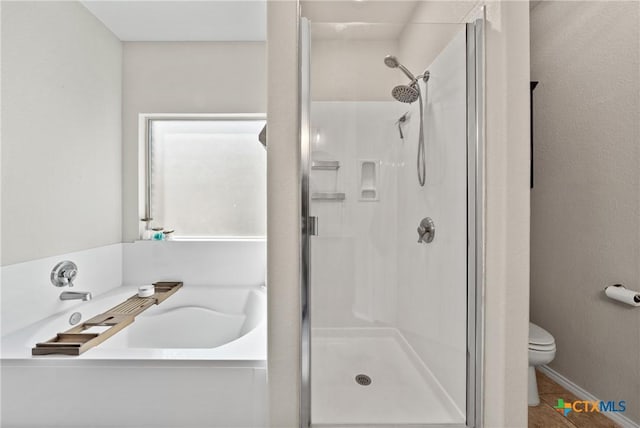 full bathroom featuring a garden tub, toilet, and a shower stall