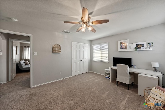 office area with carpet flooring, ceiling fan, visible vents, and baseboards