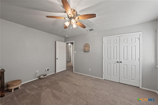 unfurnished bedroom featuring visible vents, baseboards, a ceiling fan, carpet, and a closet