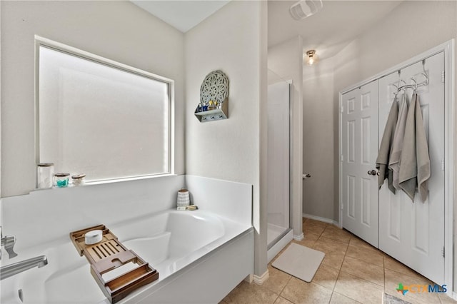 bathroom with a shower stall, a bath, and tile patterned floors