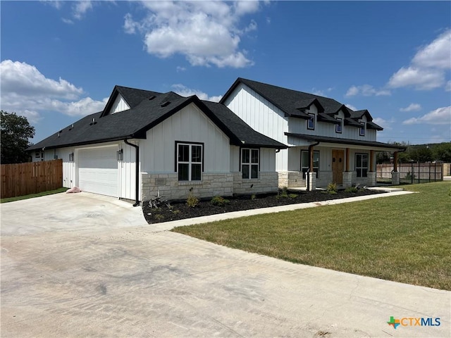 view of front of home featuring a porch, a garage, and a front lawn