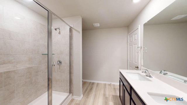 bathroom featuring walk in shower, vanity, and hardwood / wood-style flooring