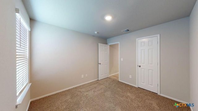 unfurnished bedroom featuring multiple windows and carpet floors