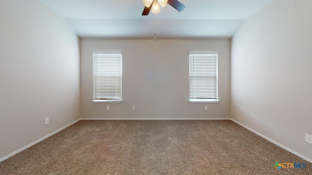 carpeted spare room with ceiling fan, plenty of natural light, and lofted ceiling