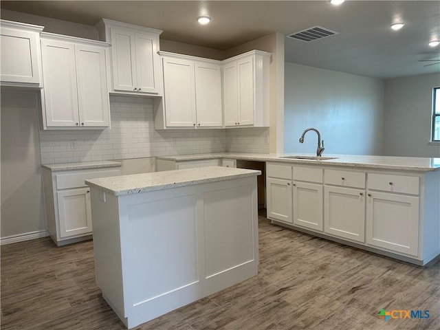 5100 Rose Petal Ct, Killeen, TX 76542 - kitchen featuring a peninsula, white cabinetry, wood finished floors, and recessed lighting