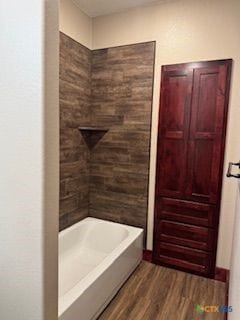 133 E Mcanelly St, Lometa, TX 76853 - bathroom with wood finished floors and washtub / shower combination