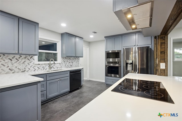 kitchen with sink, backsplash, gray cabinetry, and black appliances