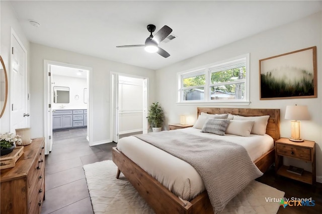 tiled bedroom featuring ensuite bath and ceiling fan