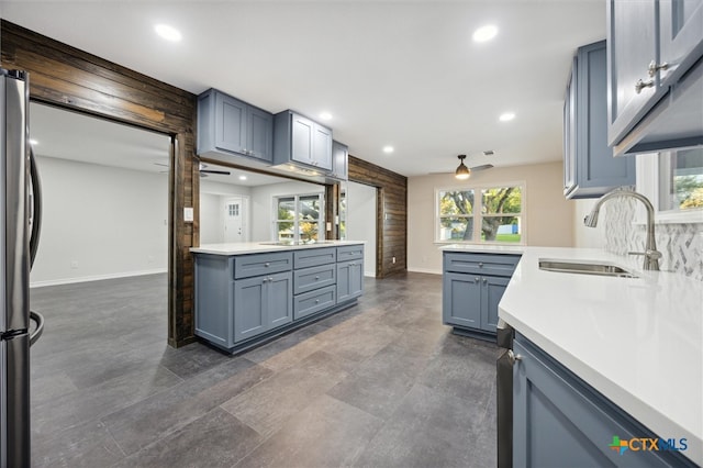 kitchen featuring stainless steel fridge, kitchen peninsula, and sink