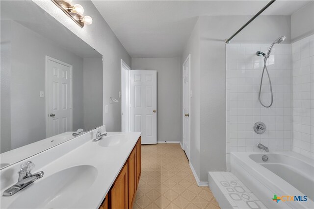 bathroom with tiled shower / bath and vanity